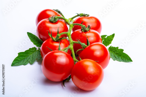 Bunch of fresh ripe red tomatoes with leaves isolated on white background