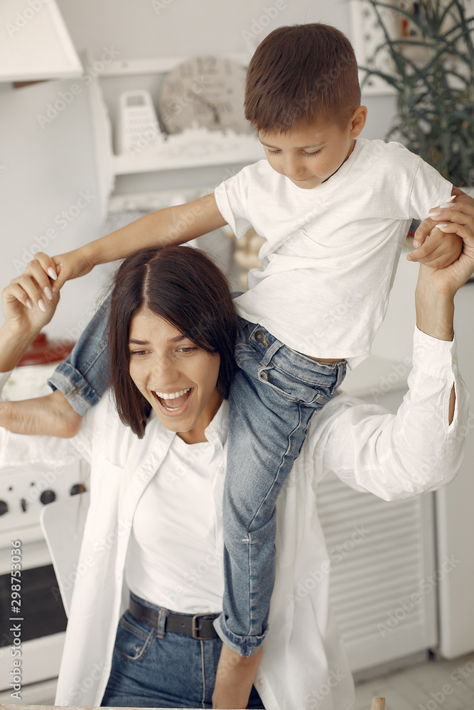 Cute little son with mother. Family at home in a kitchen