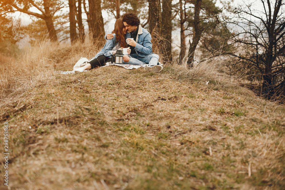 gentle and stylish couple sitting in the autumn park and drinking a tea gentle and stylish couple sitting in the autumn park and drinking a tea