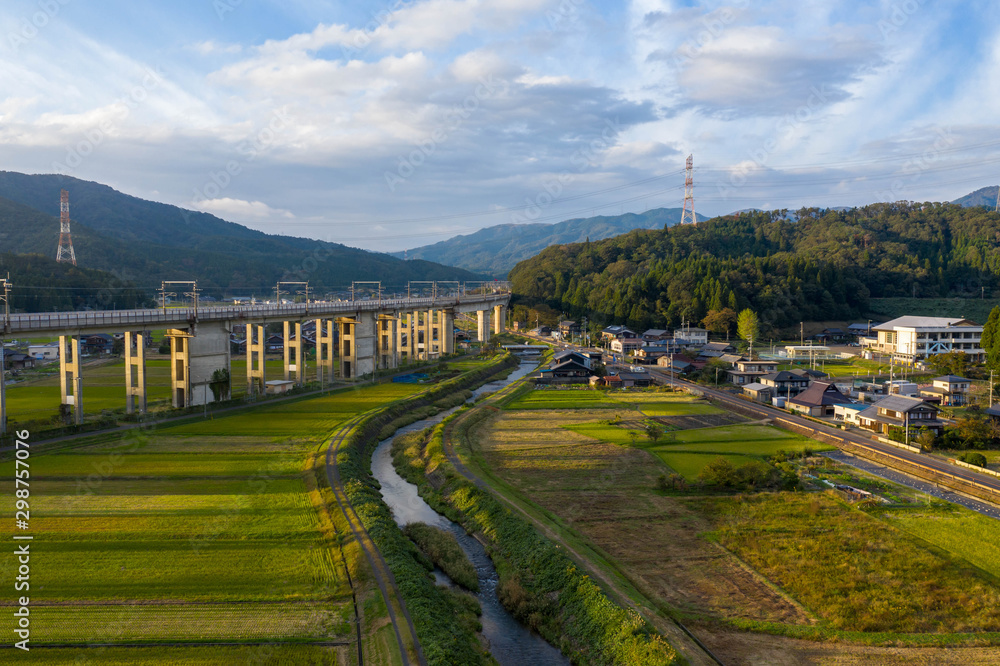 Beautiful sunset over Japan train line and rural farming village background
