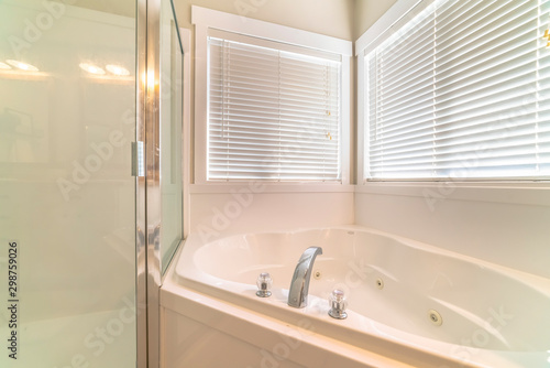 Clean bathroom interior of a home with shower stall adjacent to the bathtub