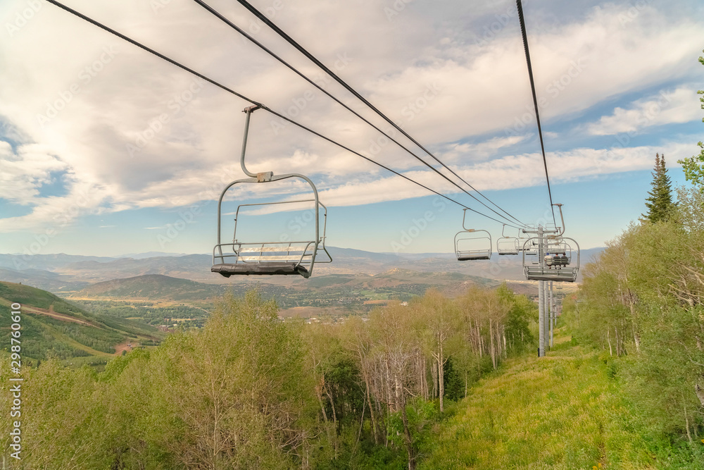 Beautiful view of chairlifts in Park City Utah under cloudy blue sky in summer