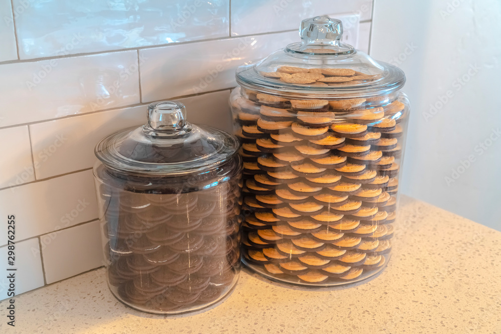 Glass storage jars filled with cookies in kitchen Glass storage jars filled with cookies in kitchen