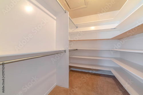 A white walk in closet with empty shelves