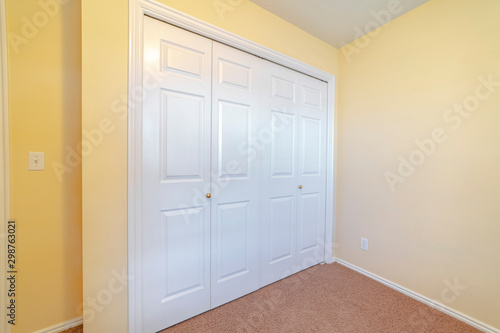 Closed white painted doors of a fitted wardrobe