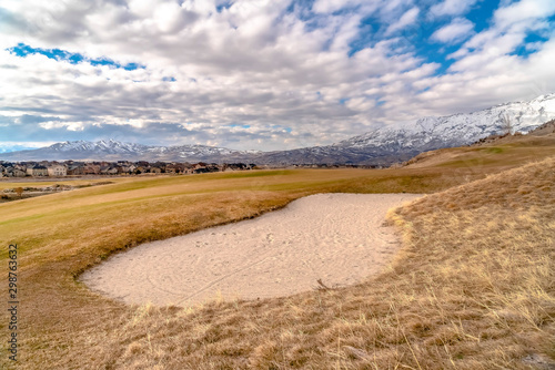 End of sand track in rolling hills in grass field sand trap