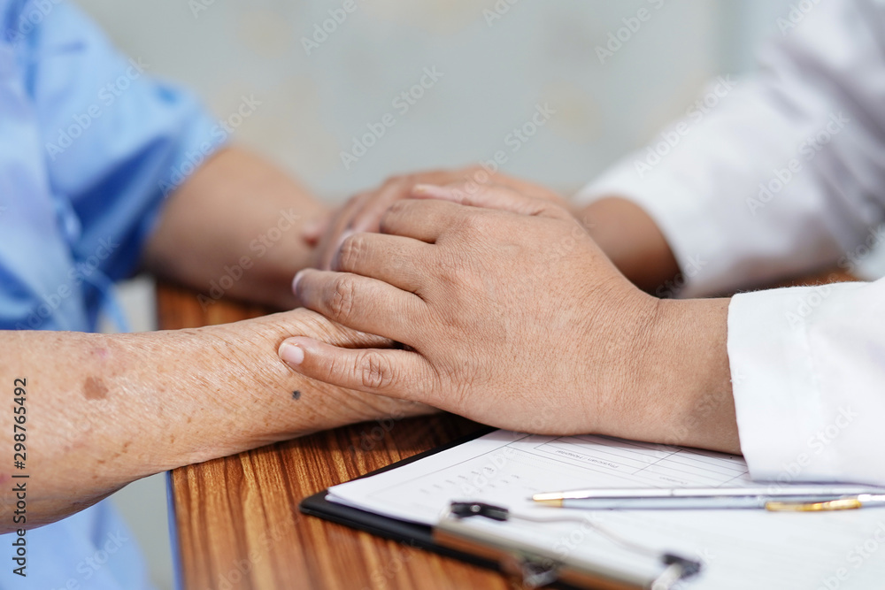 Holding Touching hands Asian senior or elderly old lady woman patient with love, care, helping, encourage and empathy at nursing hospital ward : healthy strong medical concept .