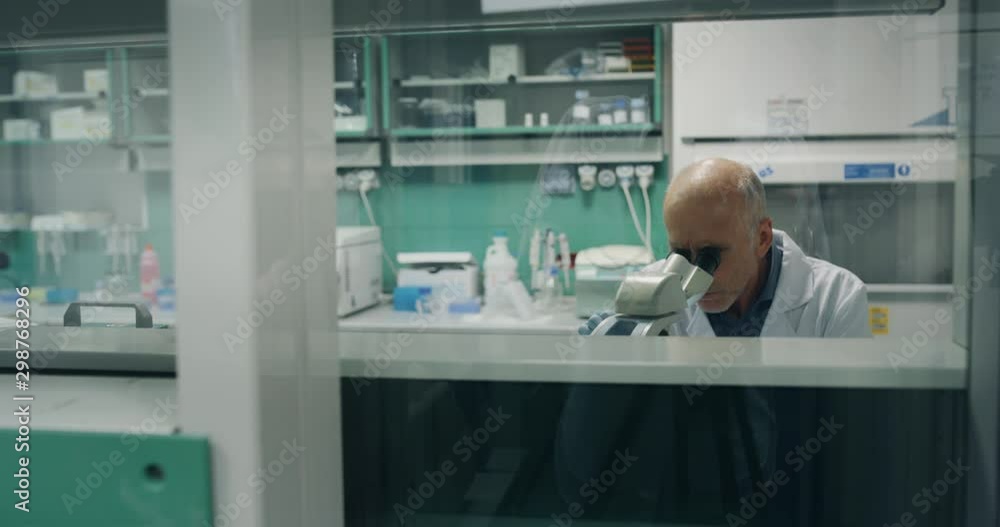 Portrait of male scientist is analyzing a sample to extract the DNA and molecules with microscope in laboratory. Portrait of male scientist is analyzing a sample to extract the DNA and molecules with microscope in laboratory.
