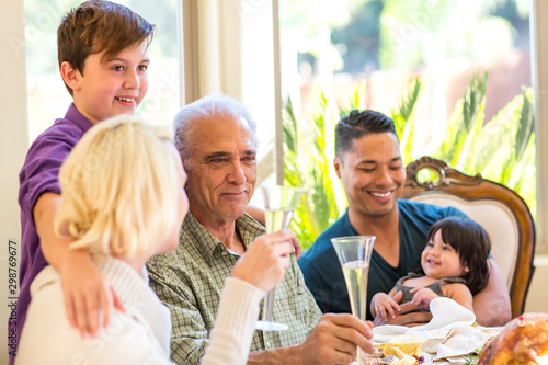 Multi generation family smiling and enjoying a holiday meal