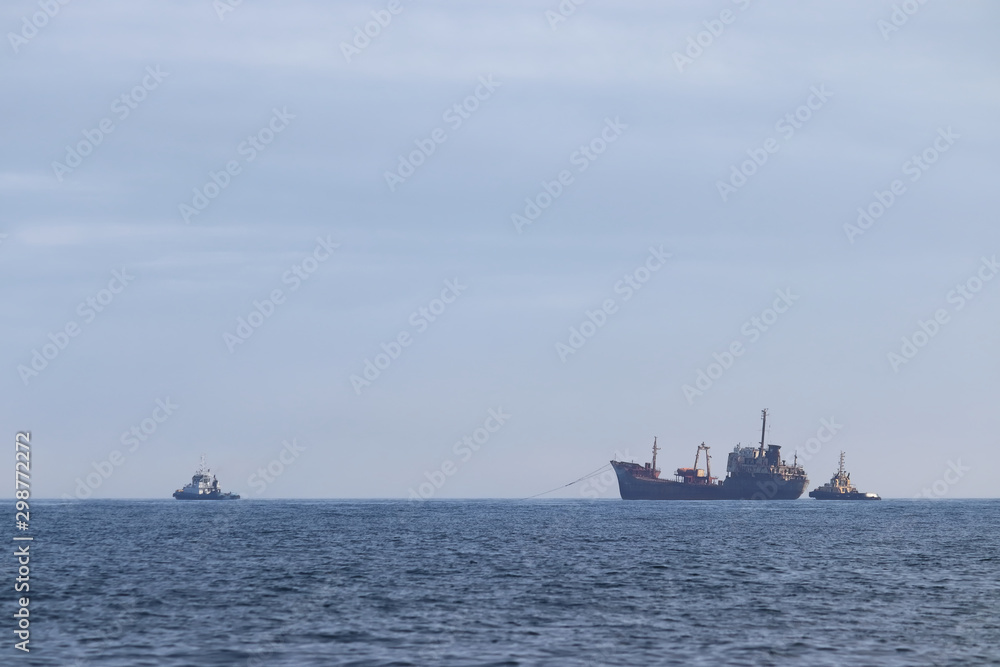 Tugboats towing the old rusty wreck ship for ship breaking. 