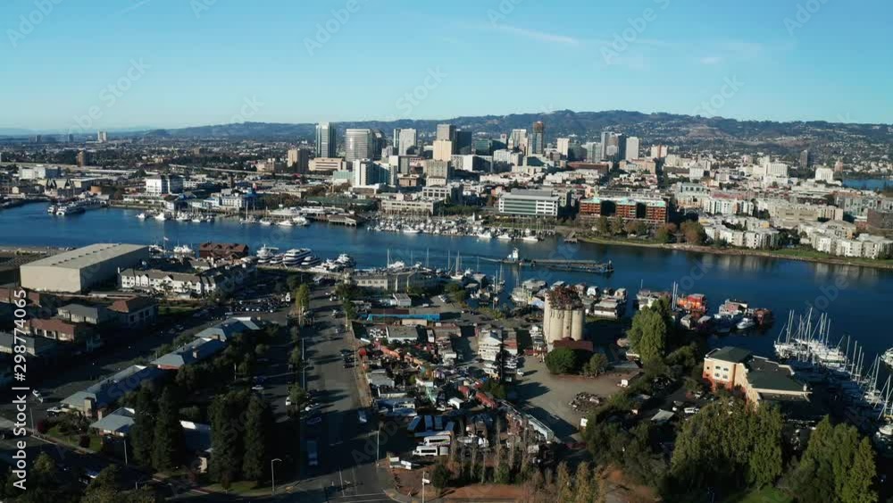 A slow and loaded ship passes along the estuary in the afternoon as the camera tracks along.