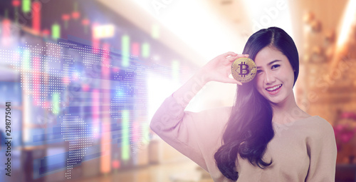 Asian woman Hand holding with golden coin by eyes on office background.Bitcoins and New Virtual money concept. photo