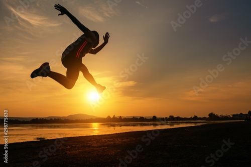 Jumping to run of the young man exercise at during sunset