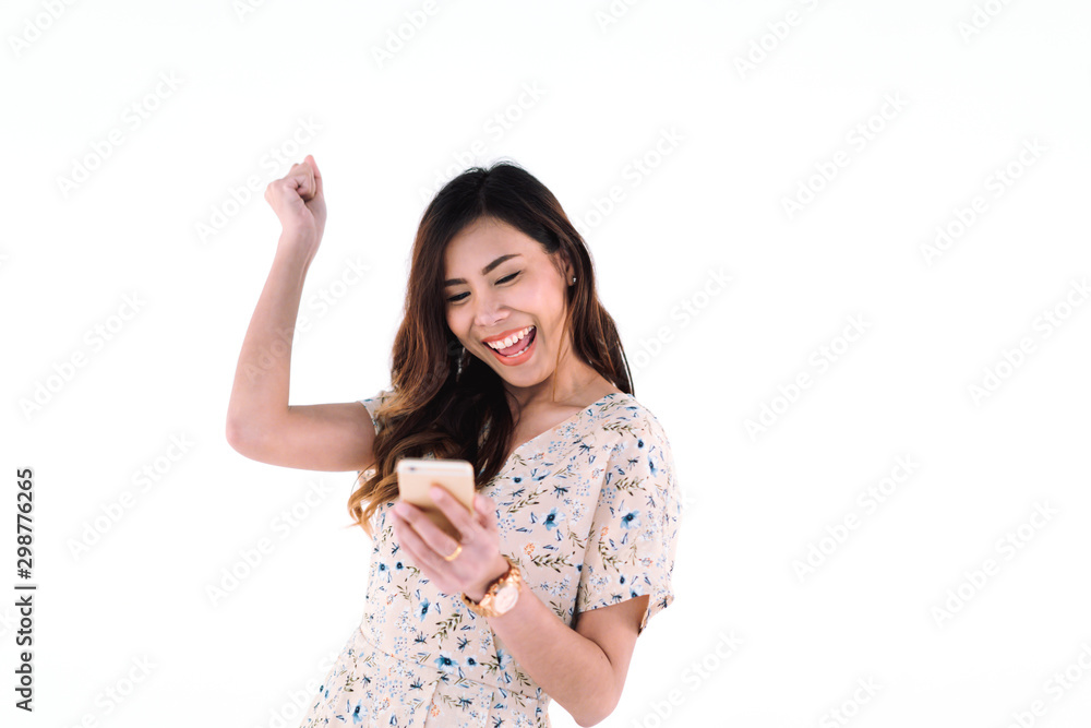 portrait of attractive asian woman smile broadly with happiness while holding phone in hand and raise her arm over head with joy in success on white background, technology and digital concept.. portrait of attractive asian woman smile broadly with happiness while holding phone in hand and raise her arm over head with joy in success on white background, technology and digital concept..