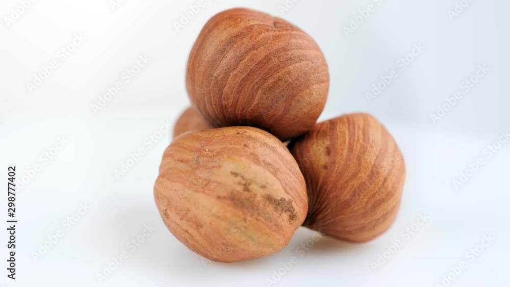 The rotation of a cluster of nuts is close. Macro. Hazelnuts on a white background. Food concept