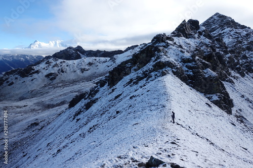 Man climbing snowy mountain crest to Viewpoint at Gosaikunda  Nepal  September 2019