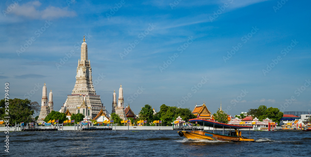 Obraz premium Świątynia Wat Arun z rzeką i łodzią transportową w Bangkoku