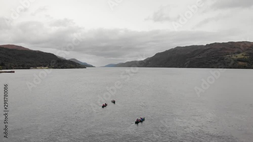 Passing over three canoes on Loch Ness on cloudy day, Scotland, aerial photo