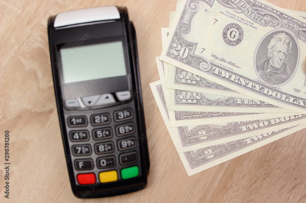 Currencies dollar and payment terminal, credit card machine on desk Currencies dollar and payment terminal, credit card machine on desk