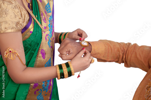 Girl tying a rakhi on her brothers hand - Image photo