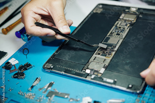 Close-up image of professional repairman assembling digital tablet