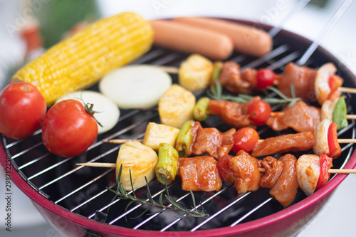 Colorful BBQ Grilling with pork ,sausage,tomato,onion,pineapple,chilli and corn on portable barbecue outdoor.