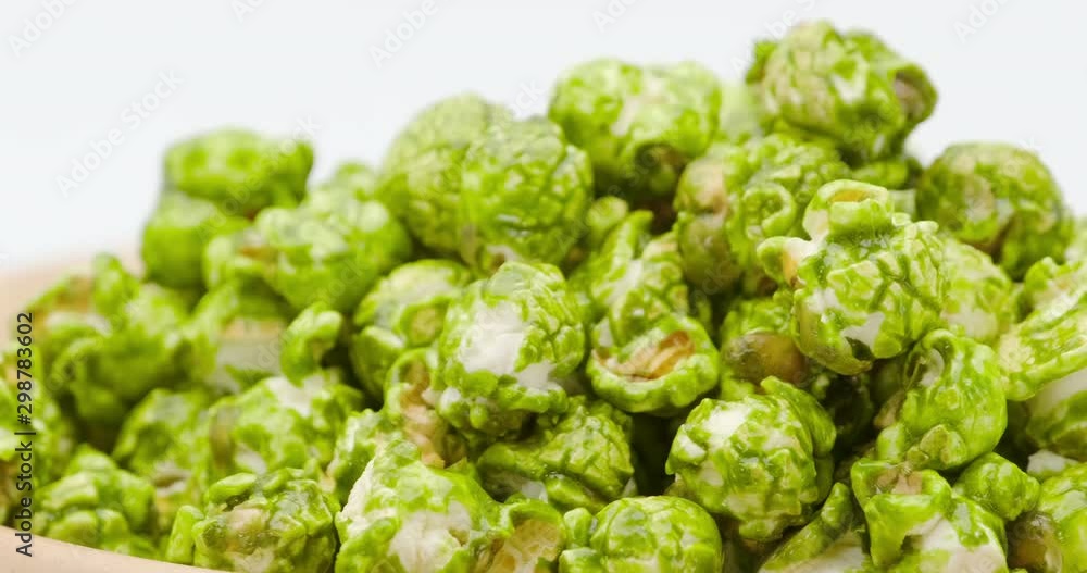 Macro truck shot of Japanese matcha green tea popcorn in the wooden bowl bulk isolated on white background Macro truck shot of Japanese matcha green tea popcorn in the wooden bowl bulk isolated on white background