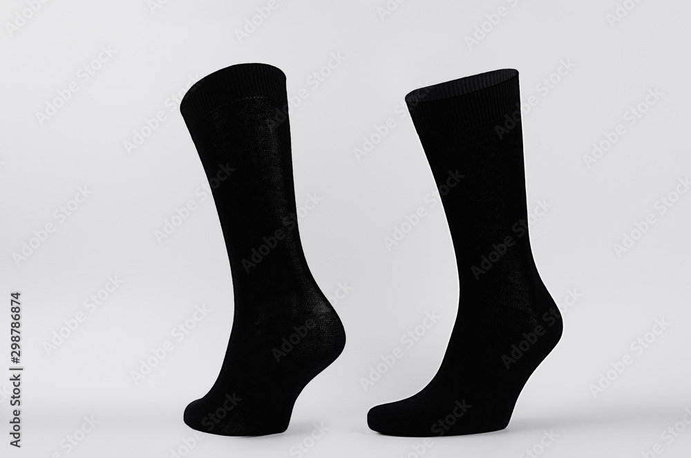 Blank black cotton high socks on invisible mannequin foot as mock up for advertising, branding, design. Front and side view, sportwear template on white background.