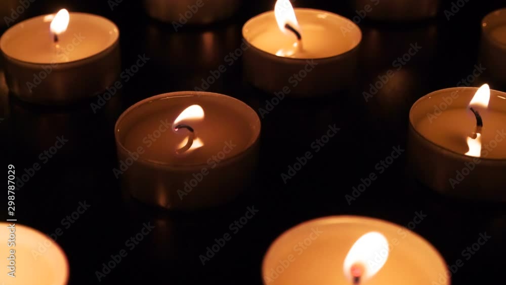 Many Little Candles. The camera moves slowly along the field with burning small candles in total darkness. Flames moving by the movement of air. Filmed at a speed of 120fps Many Little Candles. The camera moves slowly along the field with burning small candles in total darkness. Flames moving by the movement of air. Filmed at a speed of 120fps