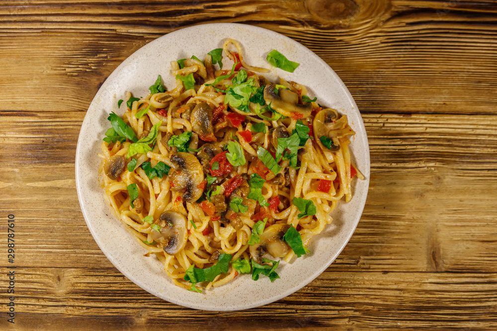 Pasta with mushrooms and tomato sauce on wooden table. Top view Pasta with mushrooms and tomato sauce on wooden table. Top view