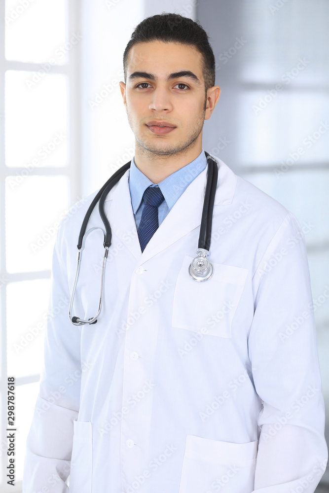 Arab doctor man standing in medical office or clinic. Physician portrait or headshot. Medicine and healthcare concept Arab doctor man standing in medical office or clinic. Physician portrait or headshot. Medicine and healthcare concept