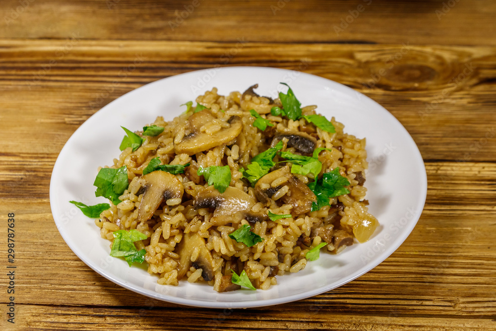 Tasty risotto with mushrooms on wooden table