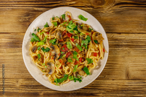 Pasta with mushrooms and tomato sauce on wooden table. Top view