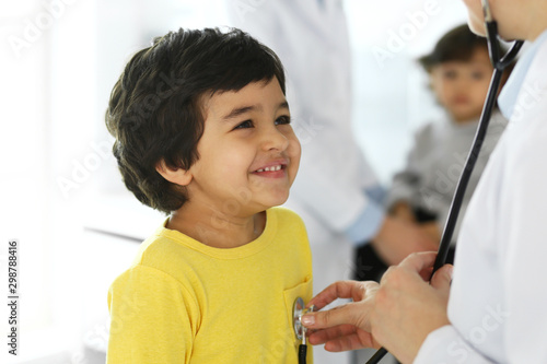 Doctor examining a child patient by stethoscope. Cute arab boy at physician appointment. Medicine and healthcare concept
