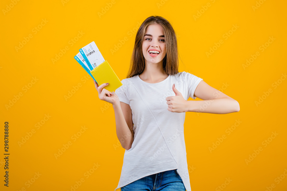 happy brunette woman with airplane tickets in passport isolated over yellow happy brunette woman with airplane tickets in passport isolated over yellow