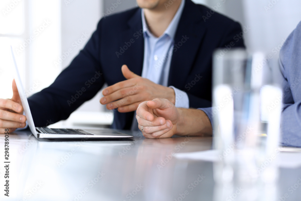 Business people using laptop computer while working together at the desk in modern office. Unknown businessman or male entrepreneur with colleague at workplace. Teamwork and partnership concept Business people using laptop computer while working together at the desk in modern office. Unknown businessman or male entrepreneur with colleague at workplace. Teamwork and partnership concept