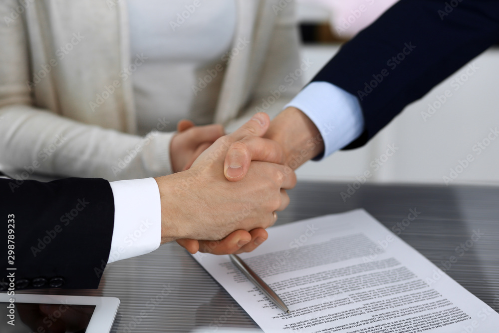 Business people shaking hands after contract signing in modern office. Unknown businessman with colleagues at meeting or negotiation. Teamwork, partnership and handshake concept Business people shaking hands after contract signing in modern office. Unknown businessman with colleagues at meeting or negotiation. Teamwork, partnership and handshake concept