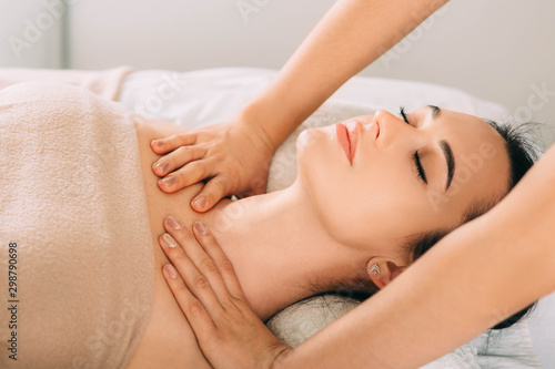 Brunette Woman relaxing during spa treatment . She receive relaxation massage while spa weekend