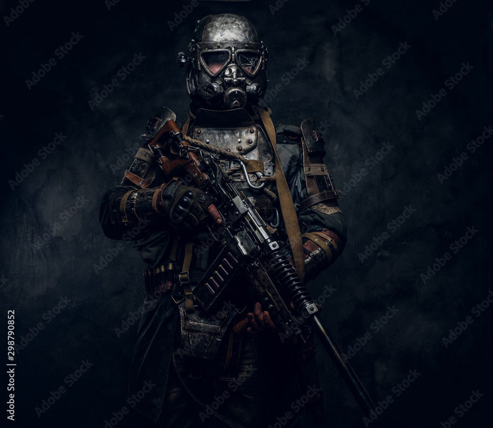 Naklejka premium Man is wearing great costume of futuristic knight in gas mask and is holding weapon.