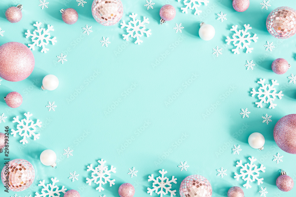 Christmas composition. Frame made of pink balls and white snowflakes on pastel blue background. Christmas, winter, new year concept. Flat lay, top view, copy space Christmas composition. Frame made of pink balls and white snowflakes on pastel blue background. Christmas, winter, new year concept. Flat lay, top view, copy space