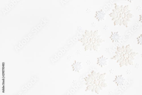 Christmas composition. Frame made of white snowflakes on white background. Christmas  winter  new year concept. Flat lay  top view  copy space