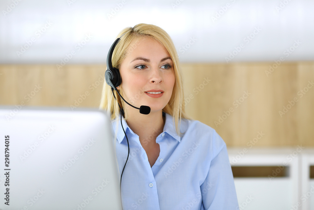 Call center. Blonde business woman sitting in headset at customer service office. Concept of telesales business or home office occupation Call center. Blonde business woman sitting in headset at customer service office. Concept of telesales business or home office occupation