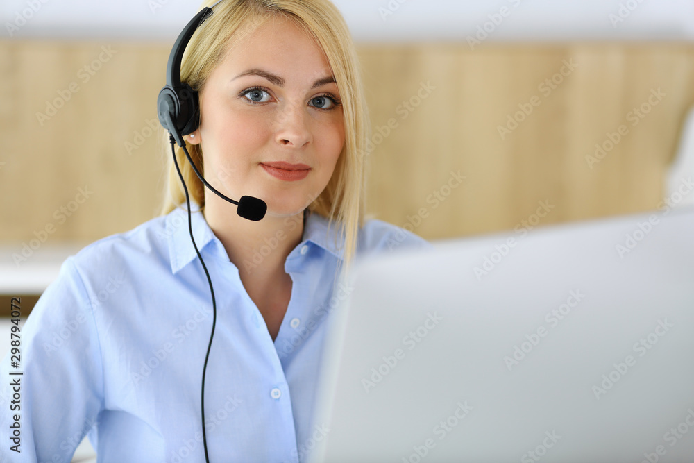 Call center. Blonde business woman sitting in headset at customer service office. Concept of telesales business or home office occupation Call center. Blonde business woman sitting in headset at customer service office. Concept of telesales business or home office occupation
