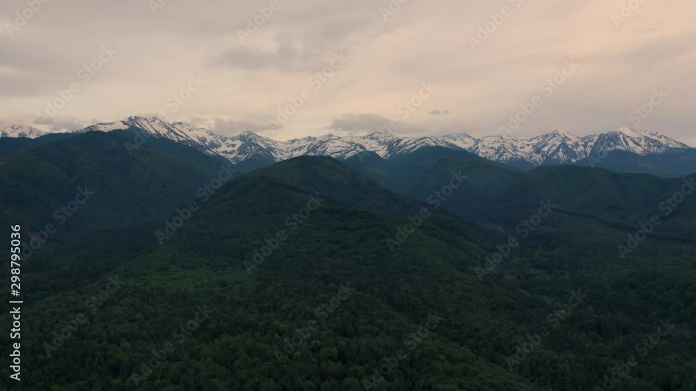 Aerial Dolly Drone shot of Negoiu mountains (neˈɡoju) covered with white snow, One of the highest mountain in Romania. Fly above green forest to cloudy rocky mountain peak in the Făgăraș Mountains Aerial Dolly Drone shot of Negoiu mountains (neˈɡoju) covered with white snow, One of the highest mountain in Romania. Fly above green forest to cloudy rocky mountain peak in the Făgăraș Mountains