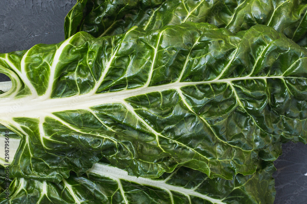 Fresh swiss chard leaves on black background. Table top view fresh organic green food Fresh swiss chard leaves on black background. Table top view fresh organic green food