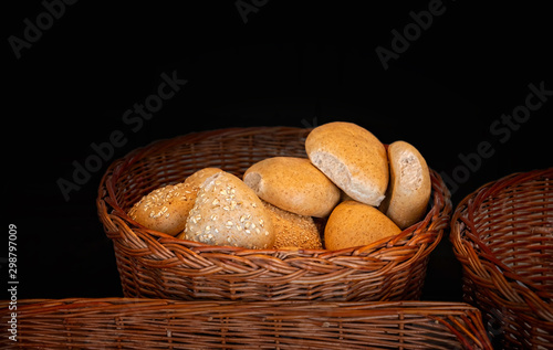 Various buns in a wooden basket on a dark background