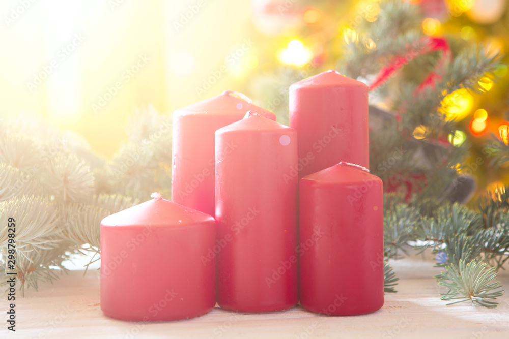 Red christmas candles on a shiny background with christmas tree Red christmas candles on a shiny background with christmas tree