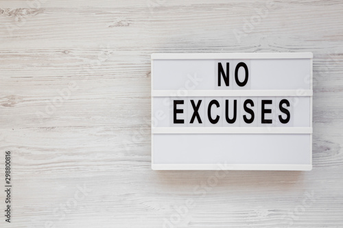 'No excuses' words on a modern board on a white wooden background, top view. Overhead, from above, flat lay. Copy space.