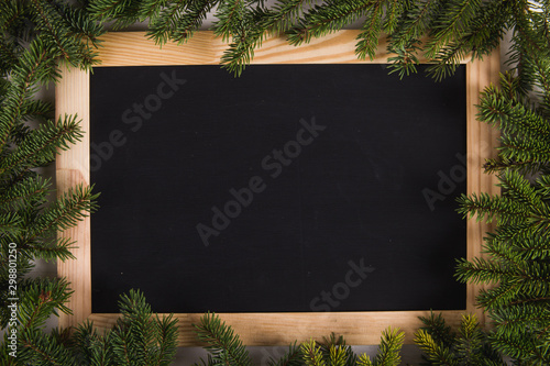 Christmas tree branches and black wooden board frame, christmas concept, greeting card. Copy space.