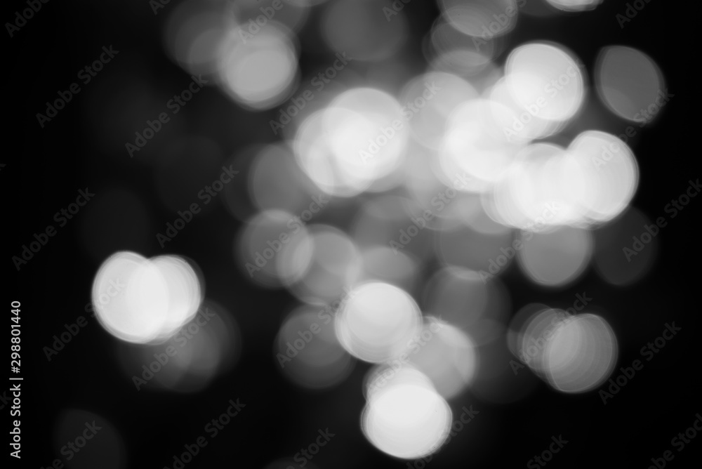 The abstract background of white bokeh on a black background. The abstract background of white bokeh on a black background.